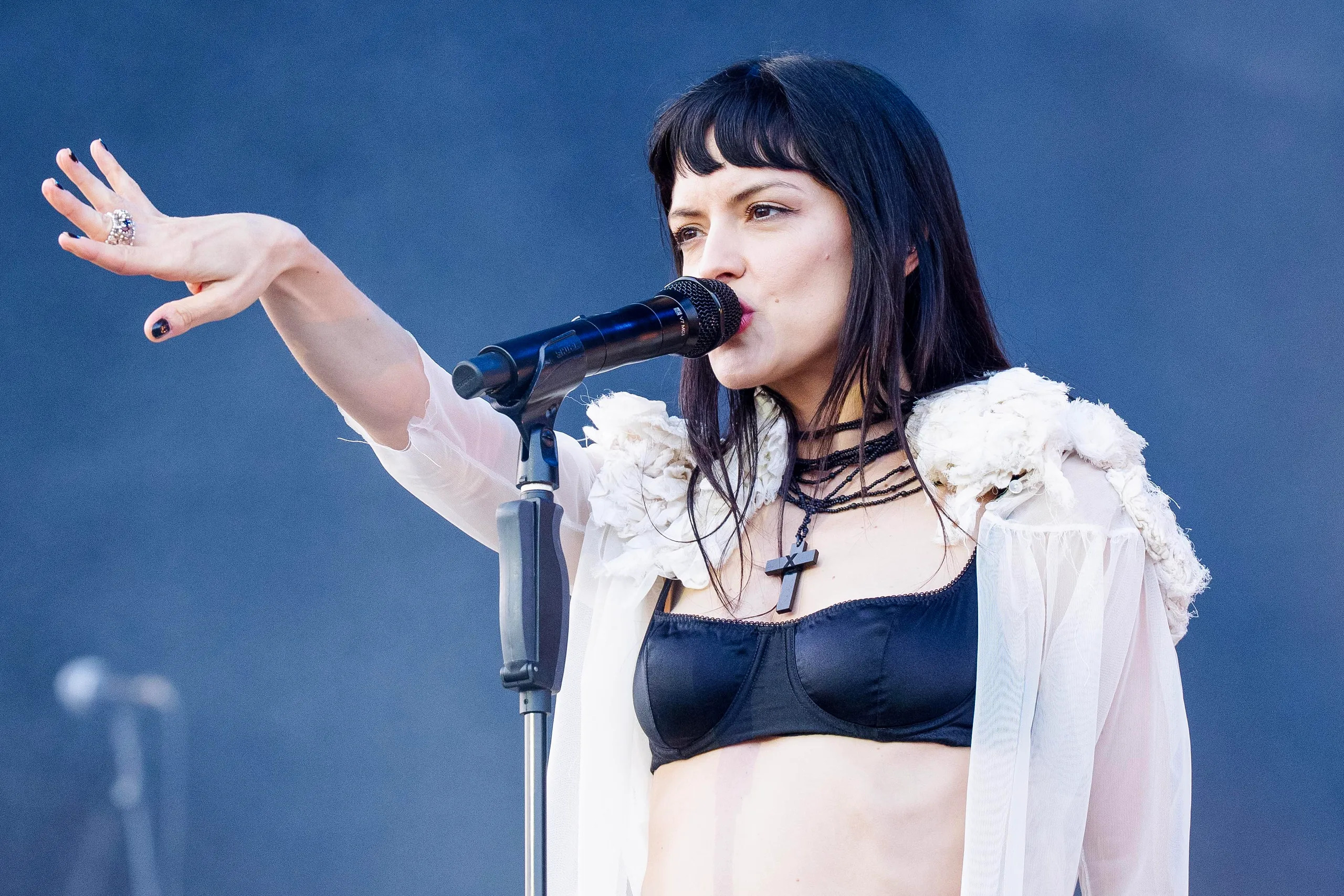 Maria Zardoya on stage with black top and sheer top buttoned open