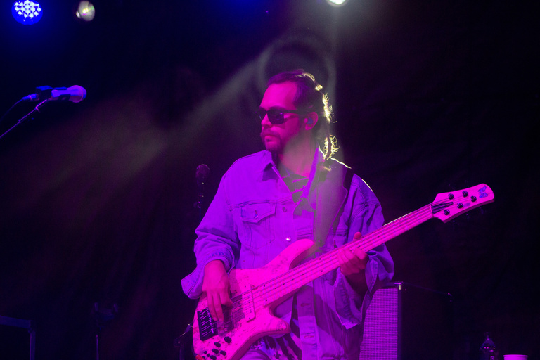 Bass player of Goose on stage with purple lighting
