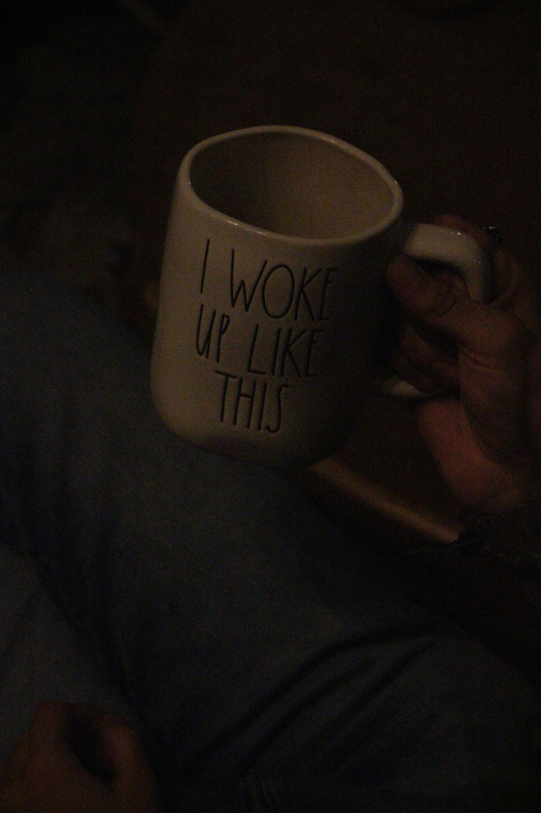 Person holding "I woke up like this" mug during the performance