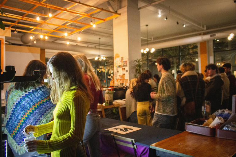 Crowd shot inside of Kindred. Lady with green shirt getting hot chocolate while others sit and enjoy the evening. 