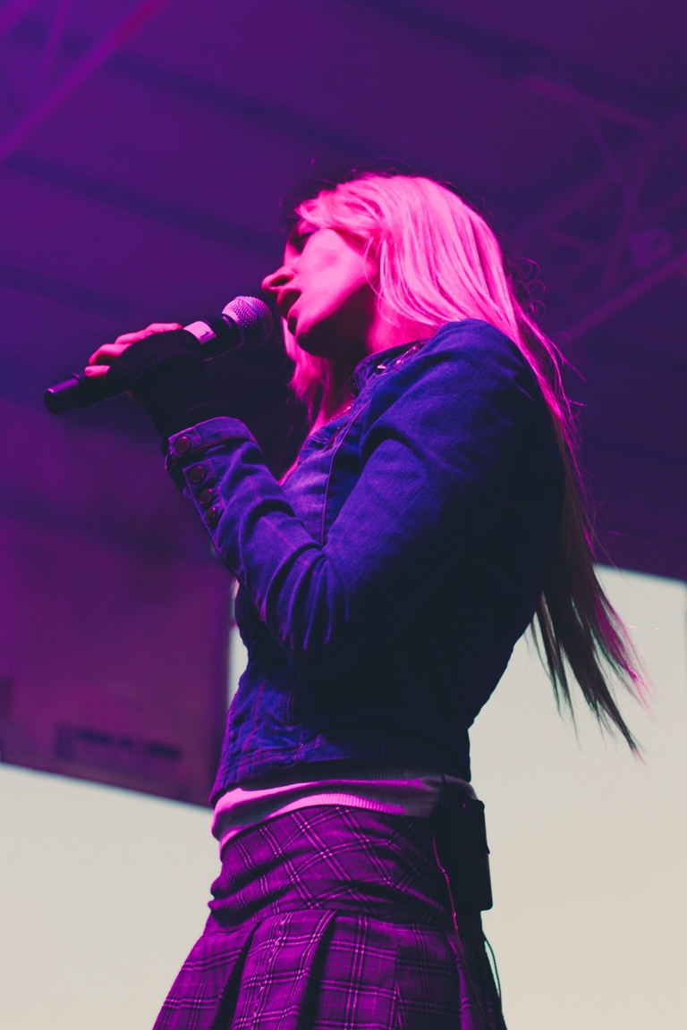 Cowgirl Clue on stage in pink lighting