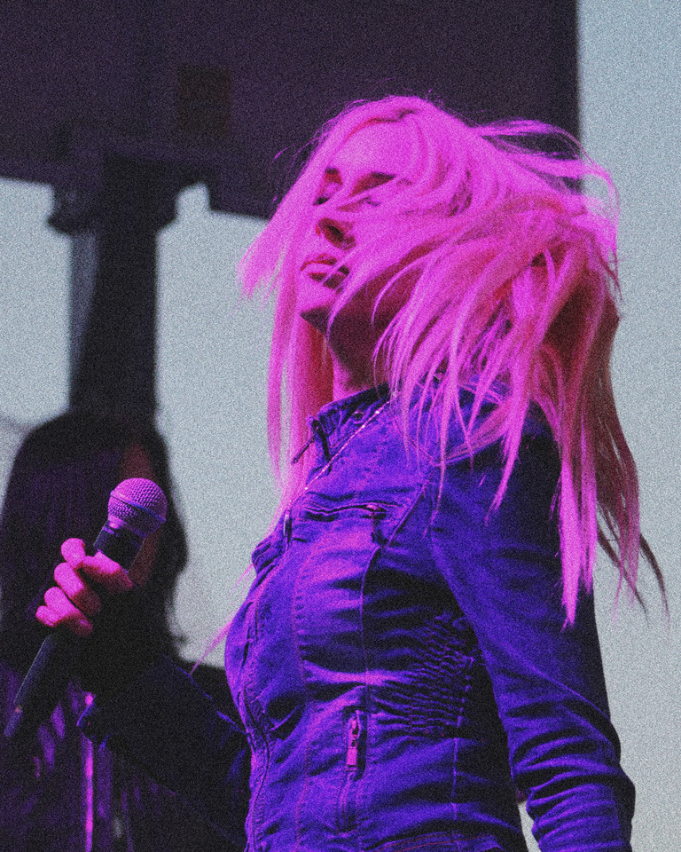 Cowgirl Clue on stage in pink lighting