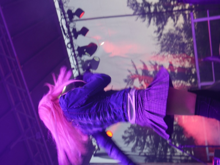 Cowgirl Clue on stage in pink lighting